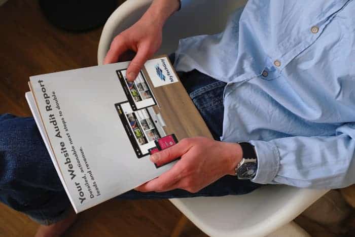 Man sat holding a website audit report